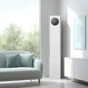 에센스 화이트 컬러의 LG 휘센 AI 오브제컬렉션 뷰I 프로 에어컨이 밝은 미니멀 인테리어 공간의 우측에 세워져 있습니다. 에어컨 본체 상단에 원형 블랙 디지털 디스플레이 화면에서 온도 정보를 숫자로 표시하고 있습니다. 에어컨은 연한 회색 벽 앞에 놓여 있으며, 벽면에는 금색 테두리에 하늘색 추상화 액자가 걸려 있습니다.