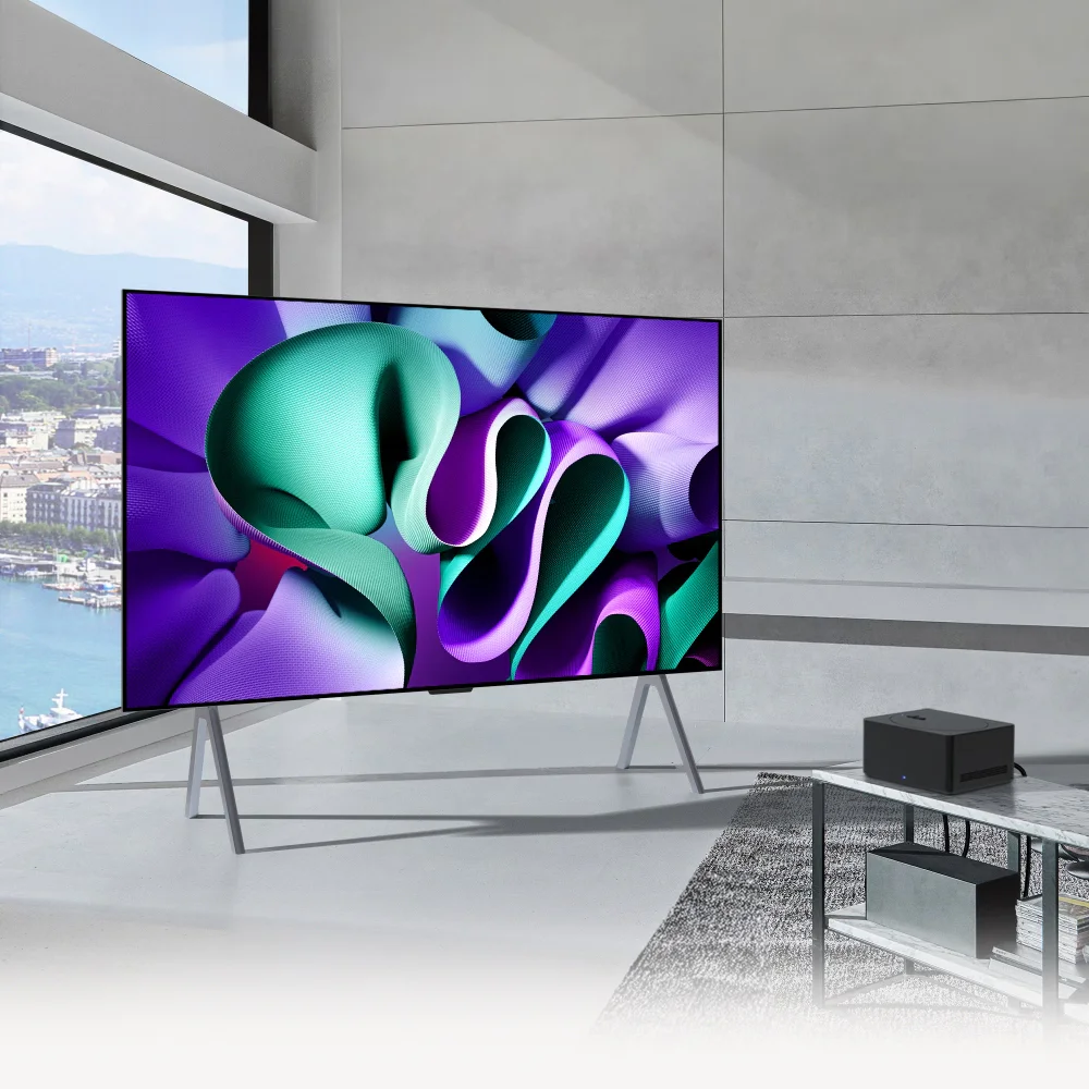 LG OLED TV가 놓인 현대적인 거실 공간입니다. 넓은 창문을 통해 도시 풍경이 보이며, 벽면은 미니멀한 회색으로 마감되어 있습니다. 슬림한 스탠드 위에 놓인 LG OLED TV에서는 다채로운 색상의 추상적인 패턴이 생동감 넘치게 표현되고 있습니다. 이 이미지는 LG OLED TV의 세련된 디자인과 뛰어난 화질을 강조하며, 현대적인 공간 연출에 대한 영