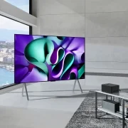 LG OLED TV가 놓인 현대적인 거실 공간입니다. 넓은 창문을 통해 도시 풍경이 보이며, 벽면은 미니멀한 회색으로 마감되어 있습니다. 슬림한 스탠드 위에 놓인 LG OLED TV에서는 다채로운 색상의 추상적인 패턴이 생동감 넘치게 표현되고 있습니다. 이 이미지는 LG OLED TV의 세련된 디자인과 뛰어난 화질을 강조하며, 현대적인 공간 연출에 대한 영