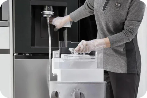 전문가 케어 - 서비스로 LG 가전 케어 전문가가 냉장고에서 분리한 얼음저장통을 세척하는 모습입니다.