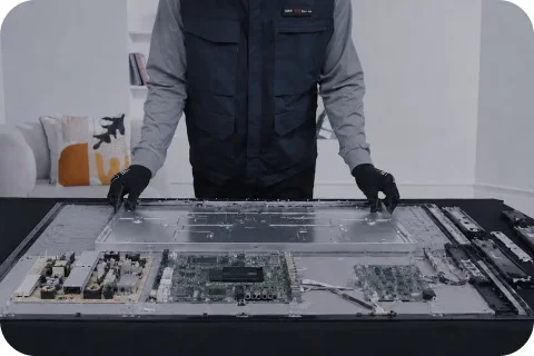 TV를 분해해 내부 부품을 점검하고 있는 모습