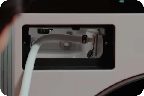 LG가전 케어 전문가가 직수 호스를 연결해 제품 내부를 고압세척하는 모습