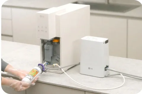 LG 가전 케어 전문가가 살균 키트를 사용하여 직수관 및 출수구를 살균하는 모습