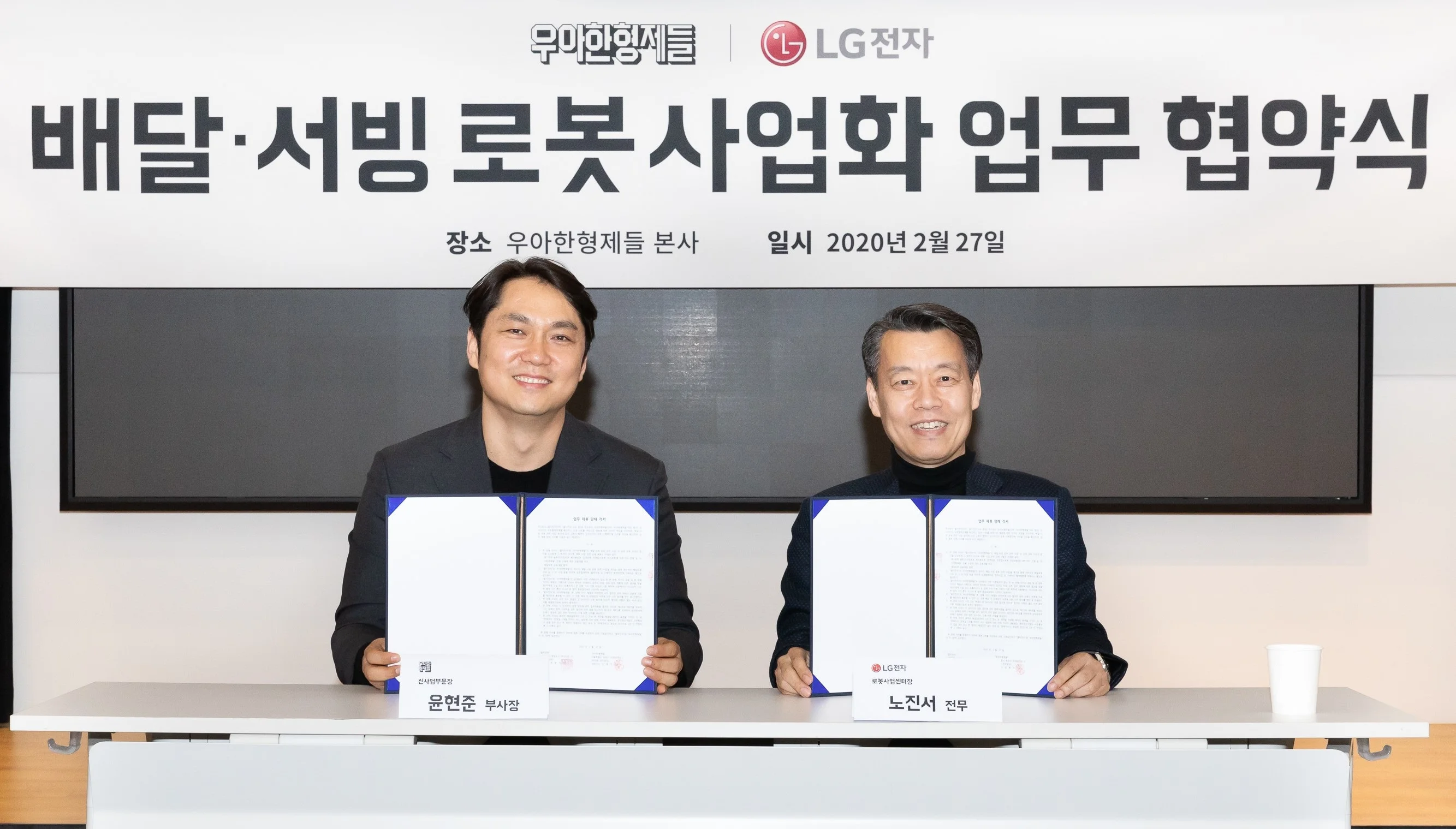 LG전자 로봇사업센터장 노진서 전무(오른쪽)와 우아한형제들 신사업부문장 윤현준 부사장(왼쪽)이 기념촬영을 하고 있다.