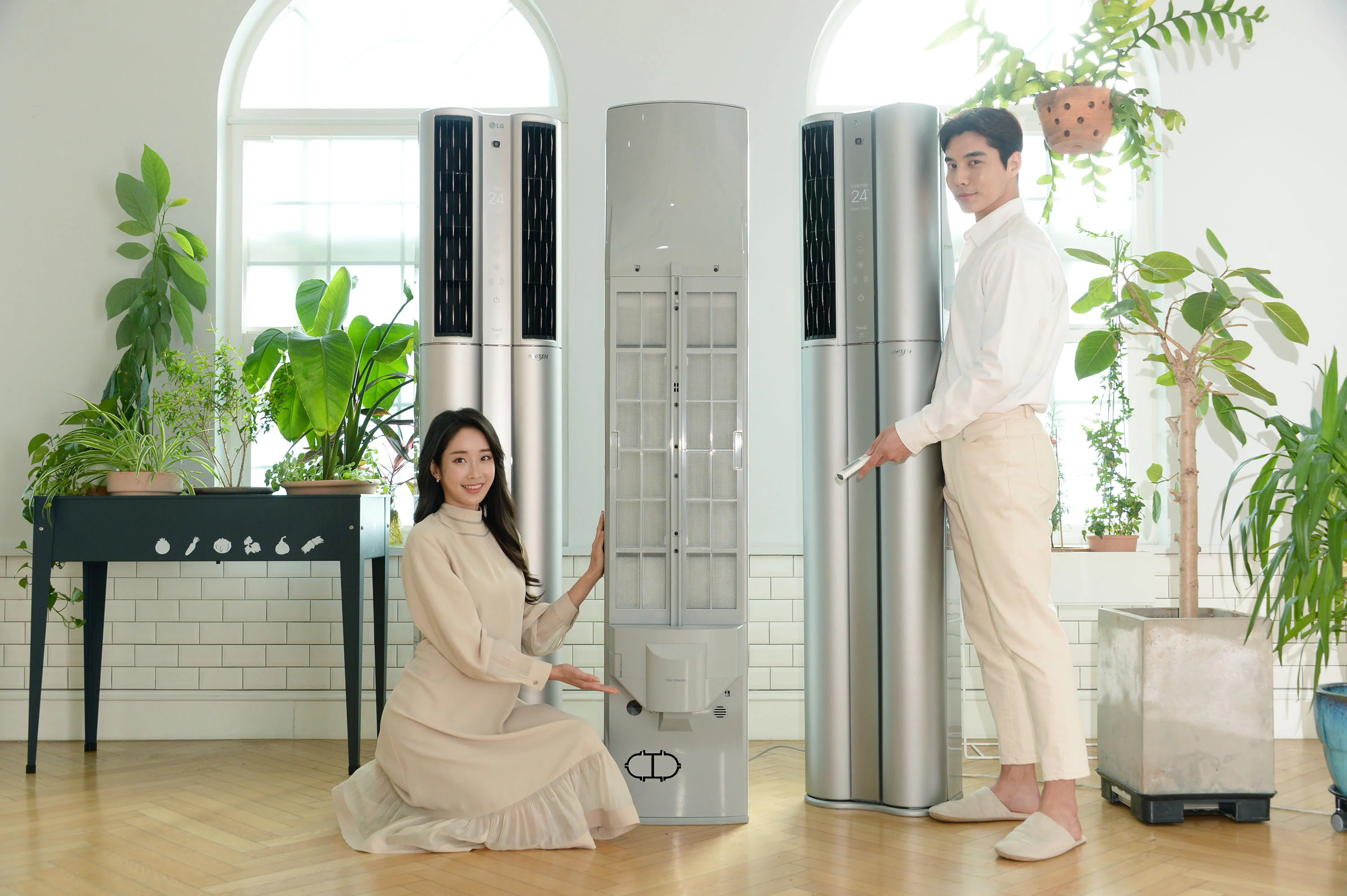 모델들은 필터클린봇과 UV LED 팬 살균 기능이 탑재된 'LG 휘센 씽큐 에어컨'을 소개하고 있다.