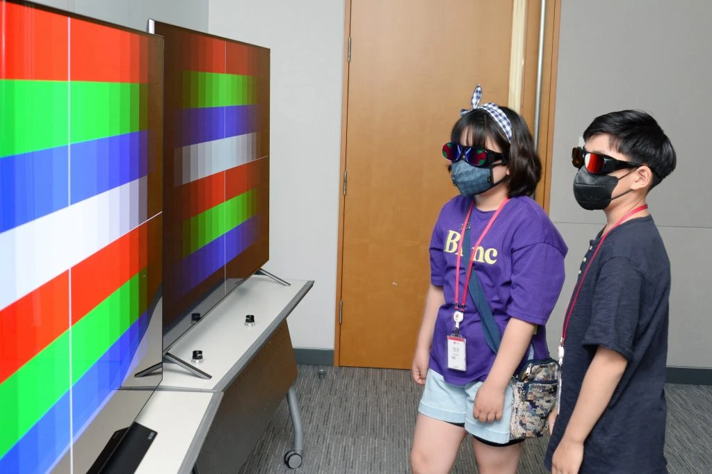 편지를 보내온 기채영 학생(사진 왼쪽)이 특수 제작된 안경을 쓰고 올레드 TV와 LCD TV 각각의 화면에서 블루라이트가 나오는 정도의 차이를 비교하고 있다.