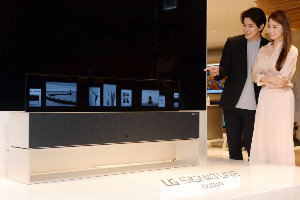 롯데백화점 본점에서 고객들이 화면을 말았다 펼치는 ‘LG 시그니처 올레드 R’을 살펴보고 있다