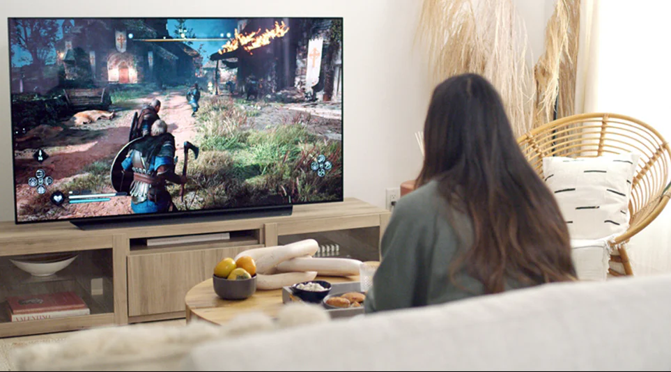 LG 올레드 TV로 거실에서 게임을 즐기고 있는 소비자의 모습 LG 올레드 TV로 거실에서 게임을 즐기고 있는 소비자의 모습