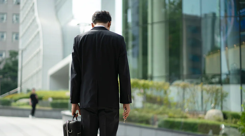 고개를 숙인 채 힘겹게 걸어가는 사회초년생 연출 이미지