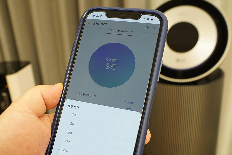 스마트폰으로 LG 퓨리케어 360도 공기청정기 알파의 청정 세기를 조절하는 모습