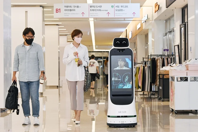 코엑스몰을 방문한 고객들이 LG 클로이 가이드봇을 바라보고 있다.  