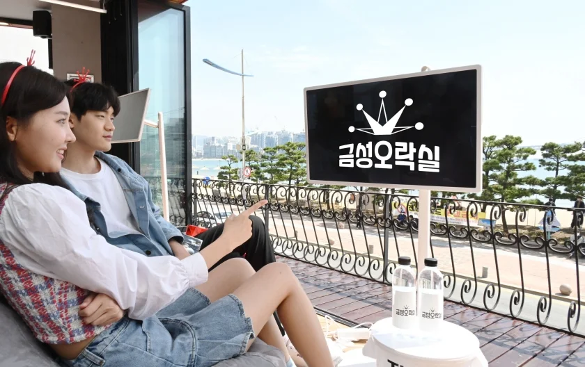 LG전자가 4월 6일부터 6월 5일까지 부산 광안리에 올레드 TV로 게임을 즐길 수 있는 ‘금성오락실’을 오픈한다. 모델들이 광안리 바다를 바라볼 수 있는 2층 라운지 공간에서 프라이빗 무선 스크린 LG 스탠바이미(StanbyME)를 체험하고 있다.