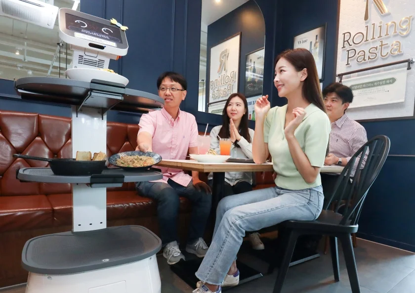 LG전자가 다양한 B2B 유·무선 통신 서비스 노하우를 쌓아온 LG유플러스와 협력해 서비스 로봇 시장을 공략한다. 양사는 더본코리아 매장 내 LG 클로이 로봇 시범 운영을 시작으로 다른 매장들로 로봇 공급 확대를 추진할 계획이다. 사진은 매장에서 LG 클로이 서브봇이 손님에게 음식을 서빙하는 모습.