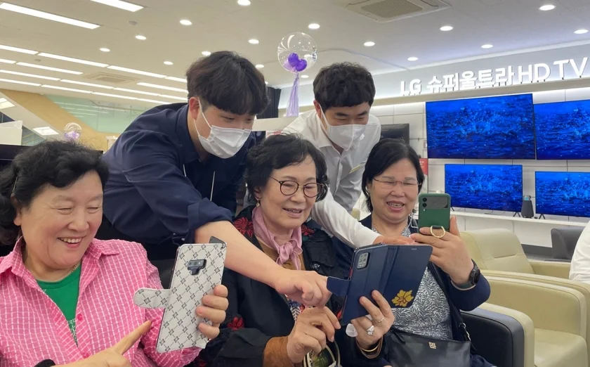 지난 22일 경기도 용인시 수지구 LG베스트샵 수지점에서 지점장과 모바일 매니저가 어르신들에게 스마트폰 활용법을 교육하고 있다.  