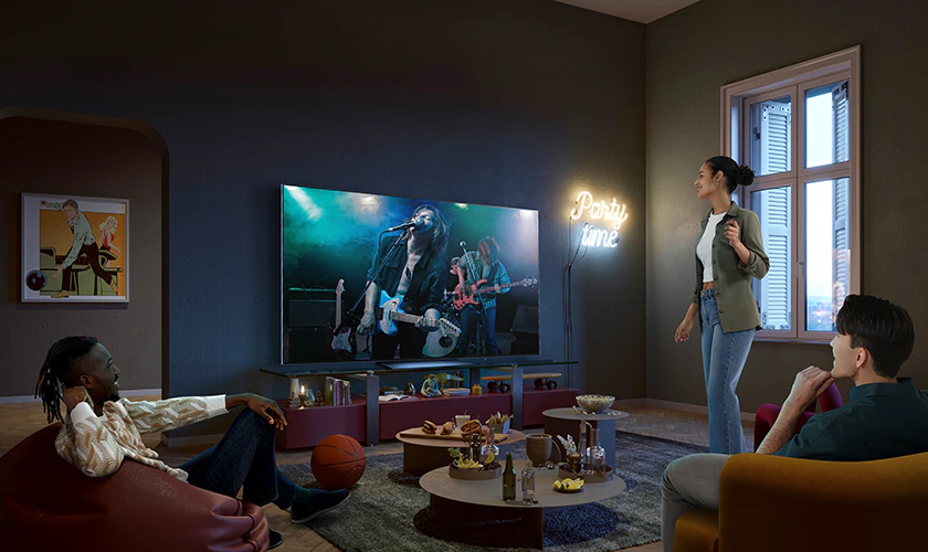 거실 소파에 앉아 맥주와 안주를 먹으며 LG 올레드 TV로 락밴드 영상을 시청하며 친구들과 즐거운 시간을 보내고 있는 사람들의 모습 