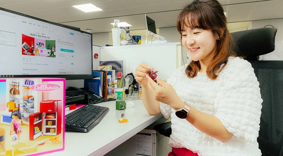LG전자 플레이모빌을 기획한 김혜진 책임이 사무실 책상에 앉아 플레이모빌 피규어를 들고 설명하고 있다