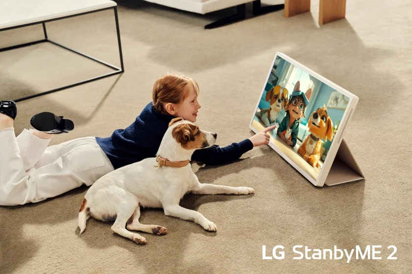 모델이 전용 액세서리를 활용해 LG 스탠바이미 2를 태블릿처럼 세워두고 사용하는 모습.