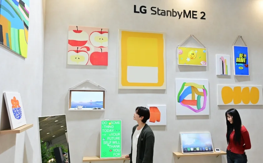 모델이 이동식 라이프스타일 스크린 'LG 스탠바이미2'를 통해 그림을 감상하고 있다.