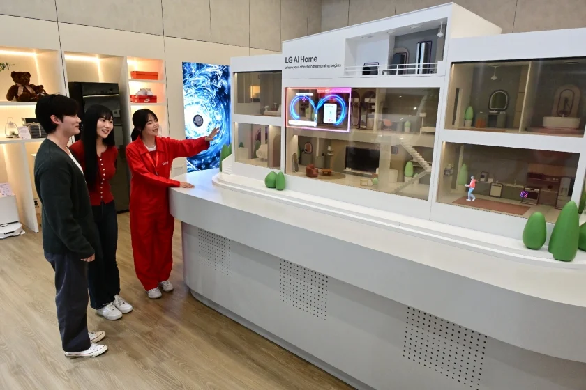 모델이 AI홈으로 더 편리해진 일상을 미니어처 모형 집과 투명 올레드로 만들어진 디오라마를 통해 표현한 'AI홈'을 체험하고 있다
