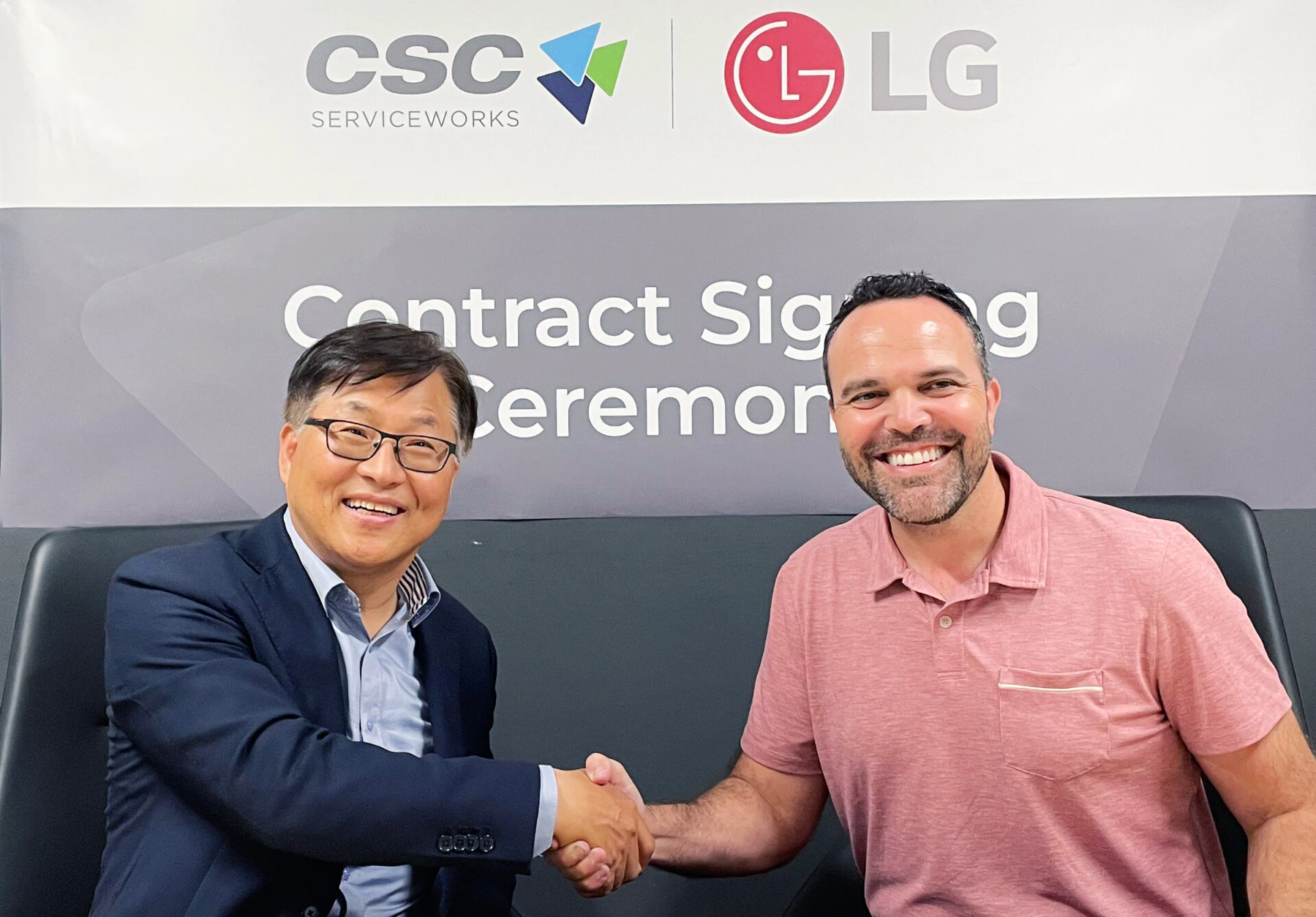 LG전자는 최근 북미 1위 세탁솔루션 기업 ‘CSC 서비스웍스(CSC Serviceworks)’와 상업용 세탁기 공급계약을 체결했다. 사진은 왼쪽부터 LG전자 미국법인 HS담당 김상용 전무, CSC 로드리고 카스텔라노스(Rodrigo Castellanos) CEO.
CSC ServiceWorks와 LG 로고가 인쇄된 배너 앞에서 두 남성이 앉은 채로 서로 악수하며 환하게 웃고 있다.
왼쪽 김상용 전무는 짧은 검정 머리를 하고 안경을 쓴 중년의 아시아인으로, 남색 정장 재킷과 연한 파란색 셔츠를 입고 있다.
오른쪽 로드리고 카스텔라노스 CEO는 짧은 머리와 수염을 기른 백인으로, 분홍색 반팔 폴로 셔츠를 입고 있다.
배경에는 "Contract Signing Ceremony"라는 문구가 회색 배너에 흰 글씨로 적혀 있어, 이 장면이 공식적인 계약 체결 현장임을 보여준다.
두 사람 모두 밝은 표정으로 서로를 바라보며 신뢰와 협력의 분위기를 연출하고 있다.