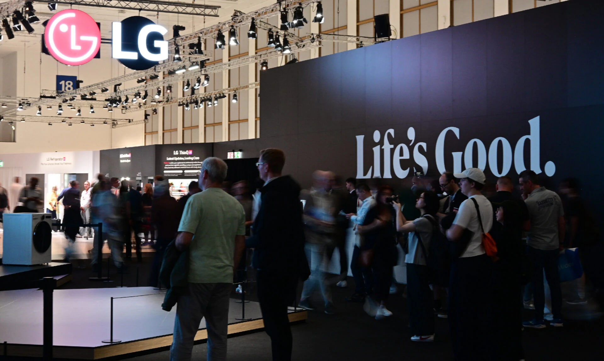 LG 로고와 'Life’s Good' 슬로건이 크게 보이는 전시 부스. 많은 관람객들이 부스를 둘러보며 이동하고 있는 활기찬 분위기의 행사장 모습